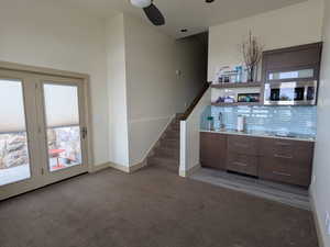 ADU living room-kitchenette with dark carpet and a ceiling fan