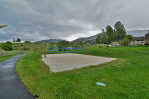Surrounding community with a mountain view and volleyball court