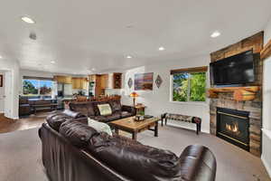 Living area featuring light carpet, a fireplace, healthy amount of natural light, and recessed lighting