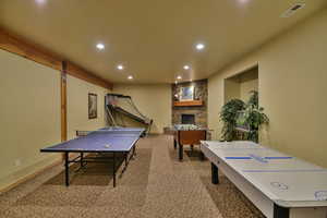 Game room featuring recessed lighting, carpet, and a stone fireplace
