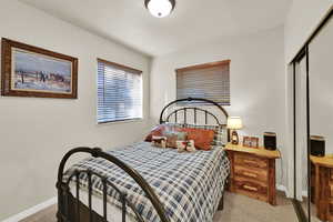 Bedroom with light carpet and a closet