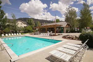 Community pool with a pergola, a patio area, and a mountain view