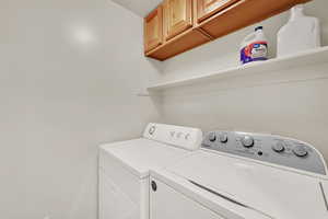 Laundry area with cabinet space and washer and clothes dryer