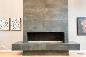 Detailed view of wood finished floors and a tile fireplace