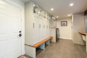 Mudroom with recessed lighting, washing machine and dryer, and dark tile patterned flooring