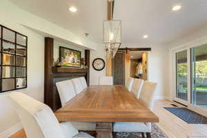 Dining space featuring a barn door, light wood-style floors, and recessed lighting