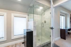 Full bathroom featuring baseboards and a shower stall