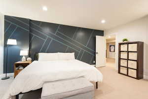 Bedroom with an accent wall, recessed lighting, a decorative wall, and carpet flooring