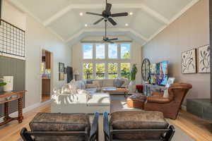 Living room featuring ornamental molding, ceiling fan, light wood finished floors, recessed lighting, and vaulted ceiling