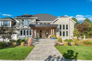 View of front facade with a front yard, covered porch, and a chimney