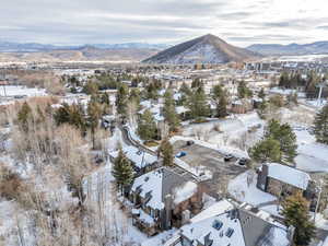 Snowy aerial view featuring a mountain view and a residential view