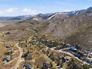 Aerial overview of property's location featuring mountains and nearby suburban area