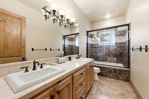 Bathroom featuring double vanity and tiled shower / bath combo