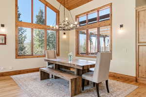 Dining area with light wood-style flooring, suspended lighting, healthy amount of natural light, and a high wooden ceiling