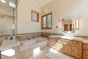 Full bathroom featuring healthy amount of natural light, vanity, a bath, and light tile patterned flooring