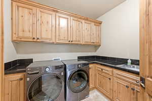 Laundry area with cabinet space and washer and clothes dryer