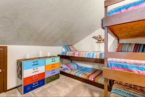 Bedroom featuring light carpet