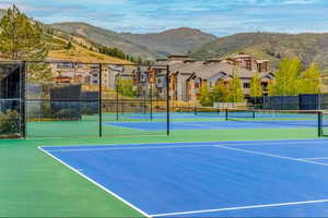View of tennis court with a mountain view and a residential view