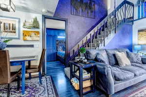 Living area with wood finished floors and a textured ceiling
