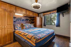 Bedroom with dark wood-type flooring, a ceiling fan, and ornamental molding
