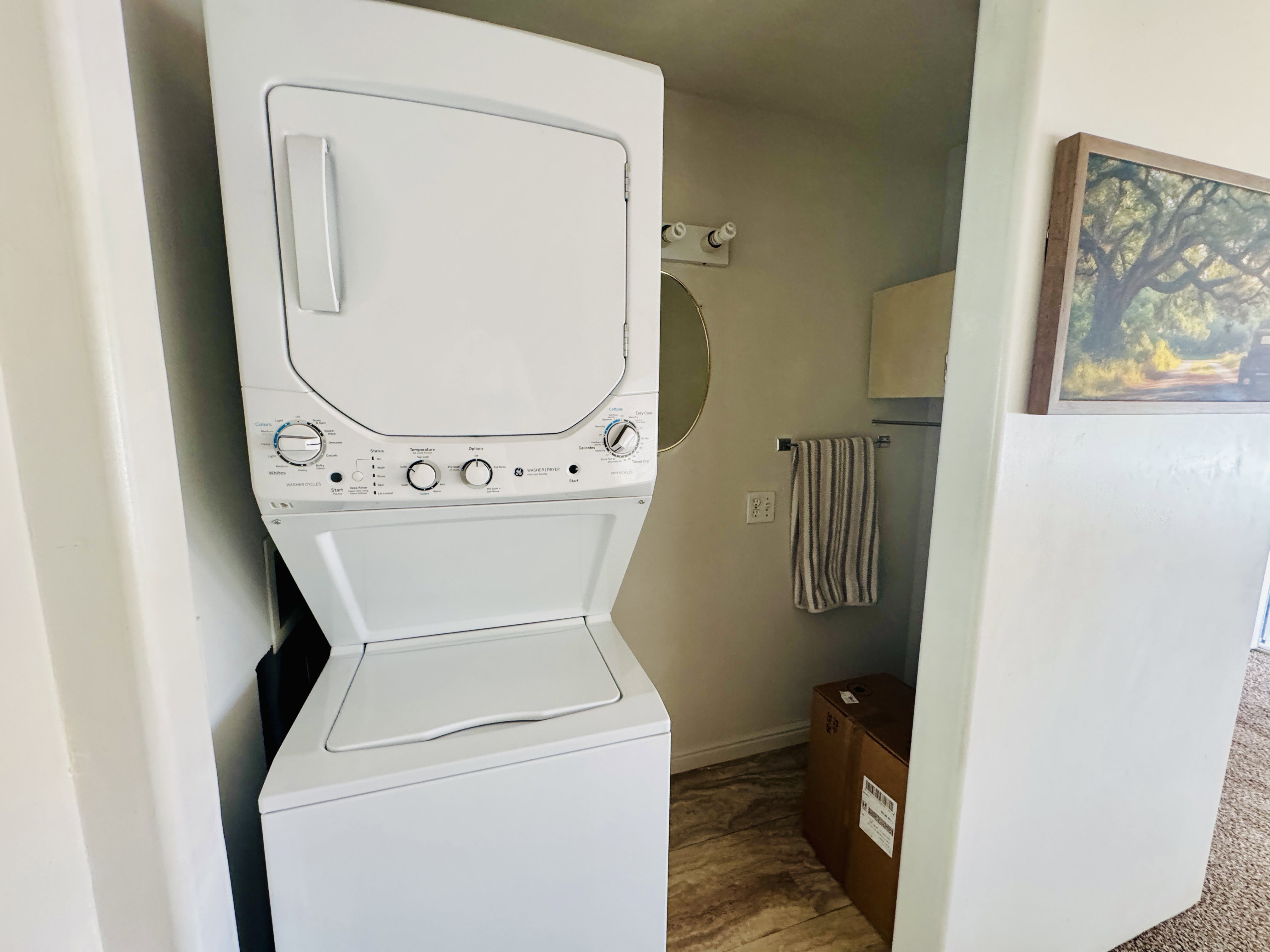 Laundry area featuring stacked washer and clothes dryer and wood finished floors