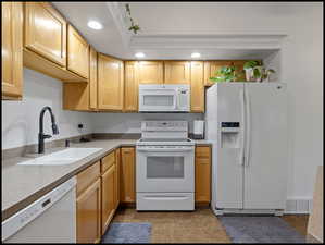 Kitchen featuring white appliances, recessed lighting
