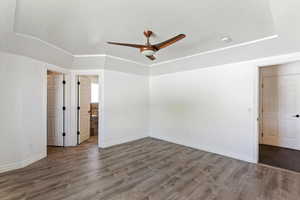 Unfurnished bedroom with ceiling fan, dark wood-type flooring, a textured ceiling, and ensuite bathroom