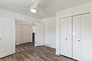 Unfurnished bedroom featuring a closet, dark wood-style flooring, and ceiling fan