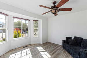 Sitting room with light wood-style flooring and a ceiling fan
