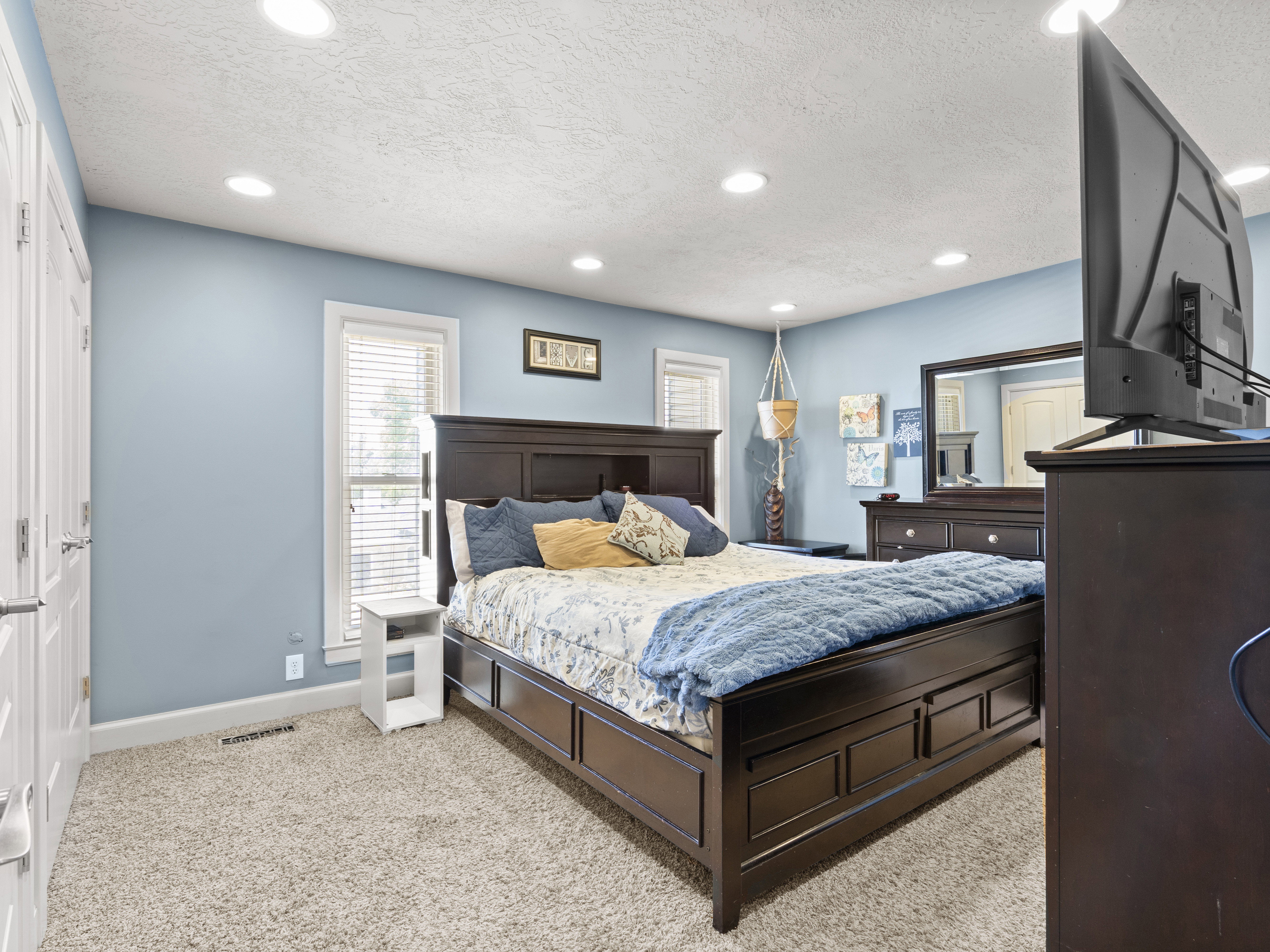 Bedroom with light colored carpet, a textured ceiling, and recessed lighting