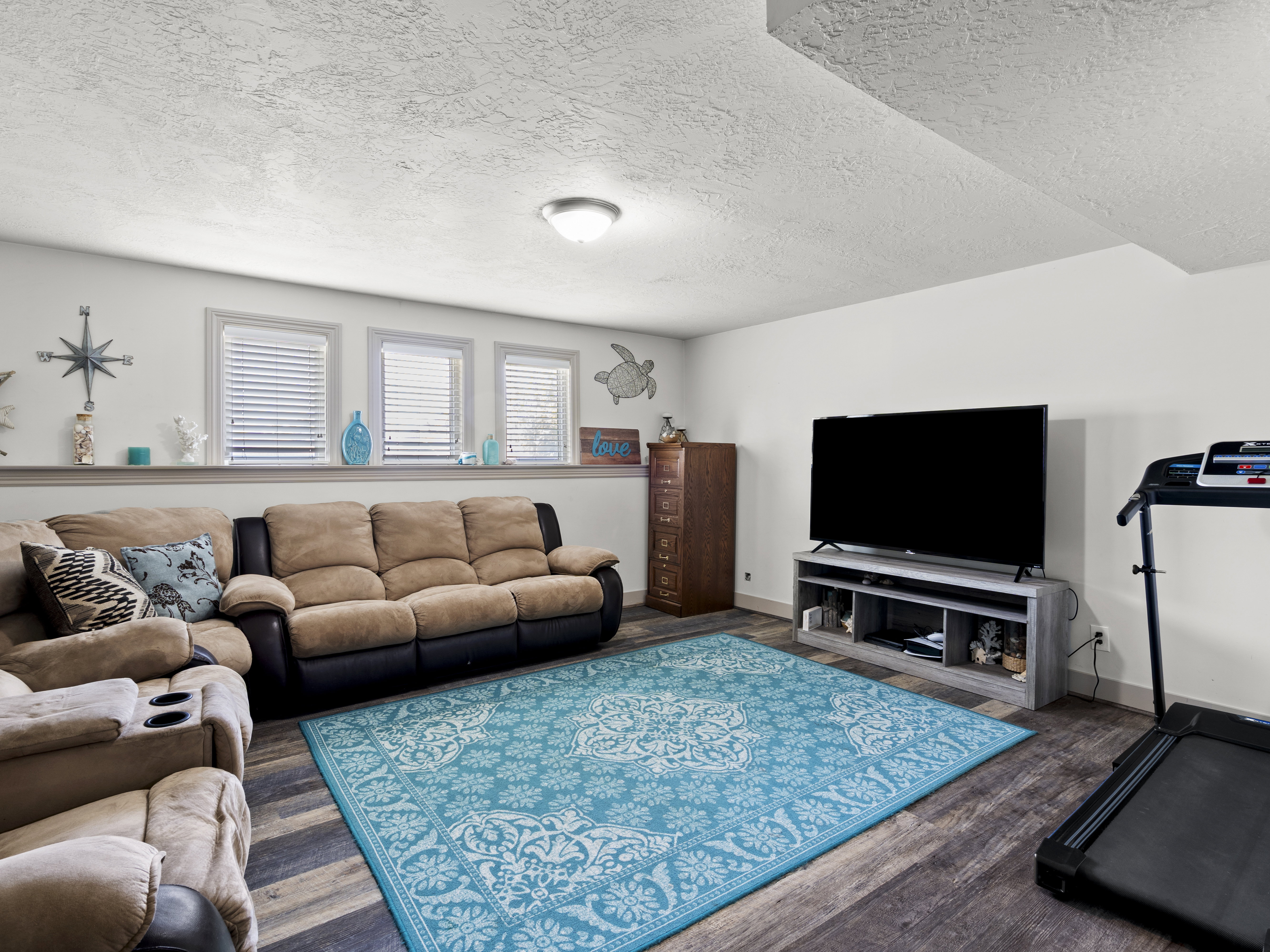 Living room featuring a textured ceiling and dark wood-style flooring