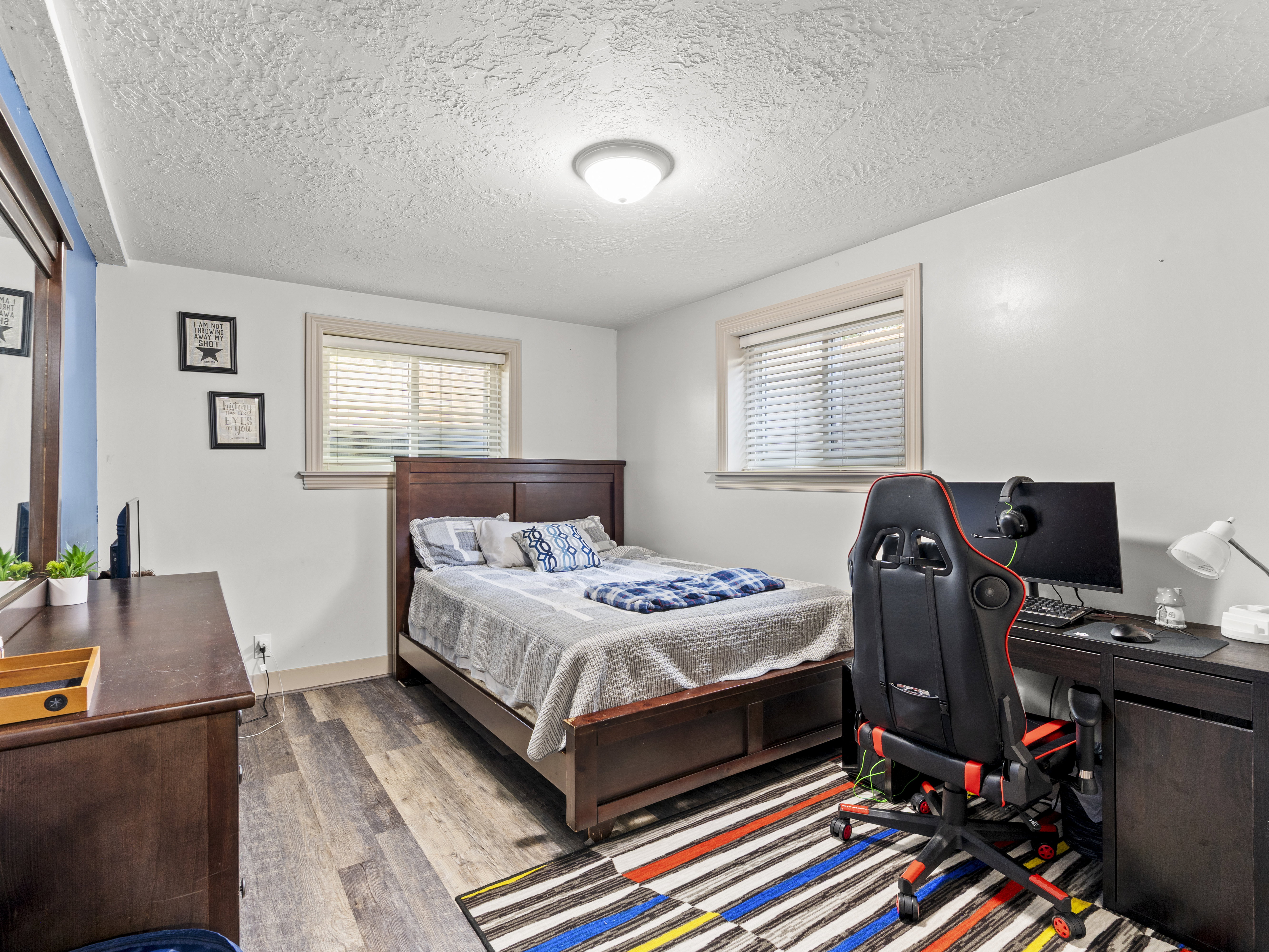 Bedroom with a desk, wood finished floors, and a textured ceiling
