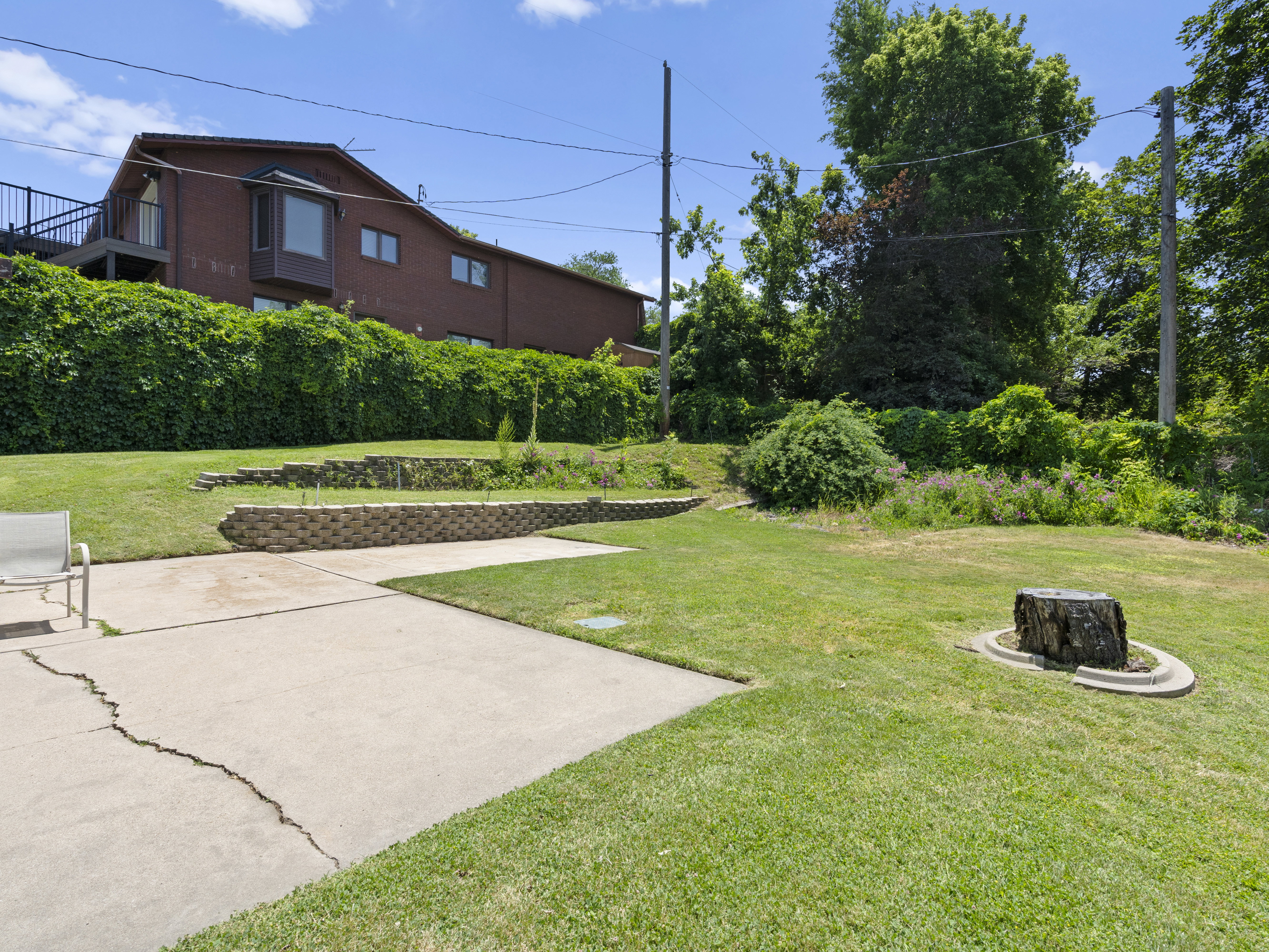 View of green lawn featuring a fire pit and a patio