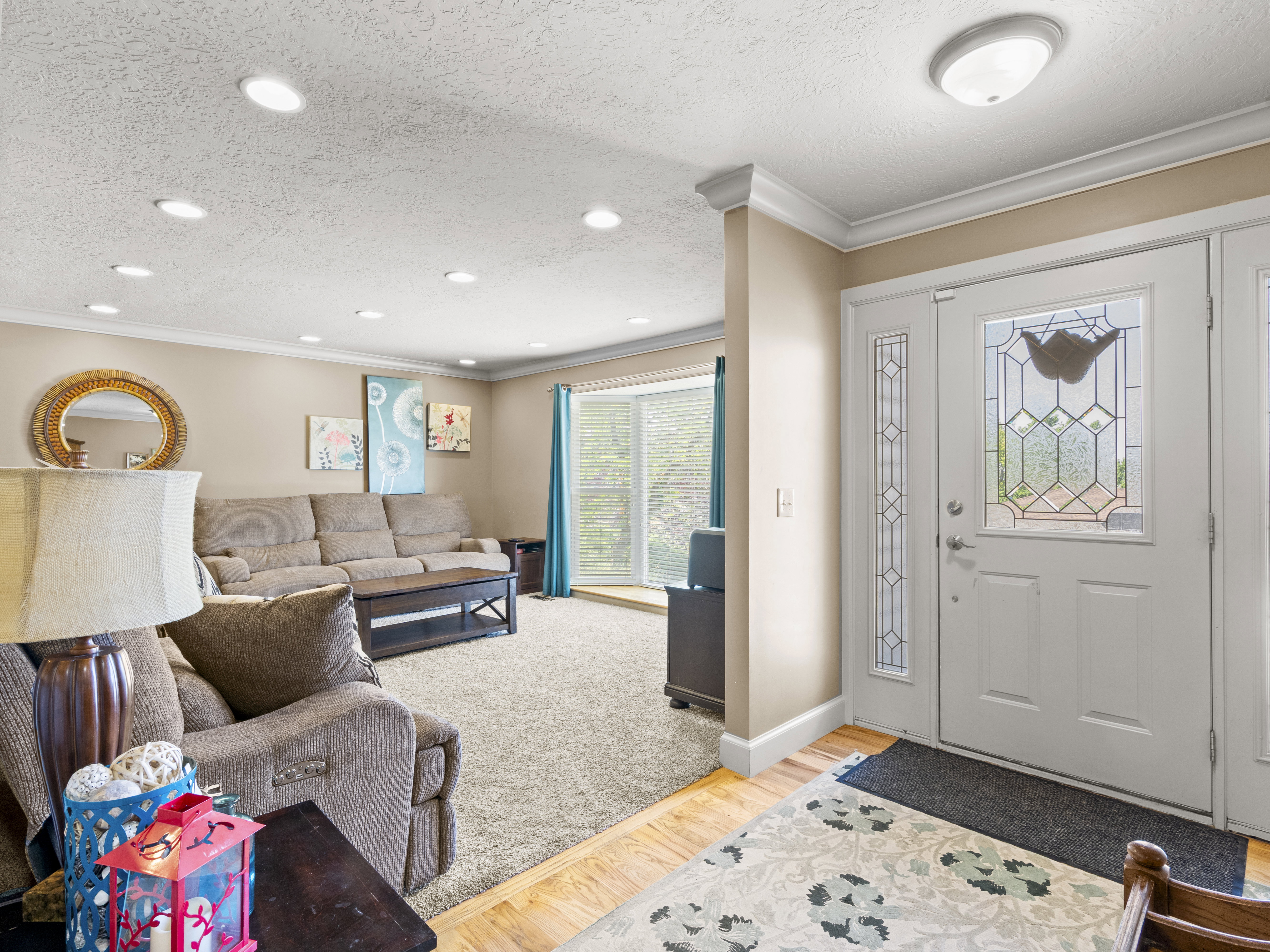 Foyer entrance featuring light wood-style floors, ornamental molding, and a textured ceiling
