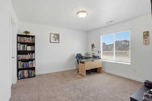 Office space featuring light colored carpet and beautiful natural light
