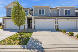 View of front facade featuring driveway and a built-in garage