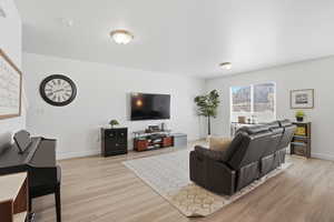 Living room with light floors. Plenty of room for TVs or bookstands!