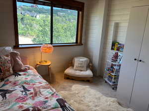 Bedroom with wood walls and light carpet