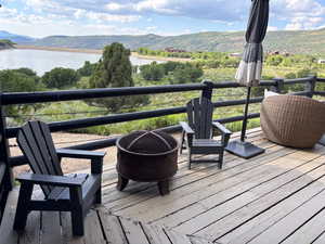 Wooden terrace featuring a water and mountain view and an outdoor fire pit