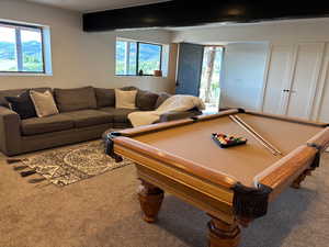 Rec room featuring carpet, plenty of natural light, pool table, and beam ceiling