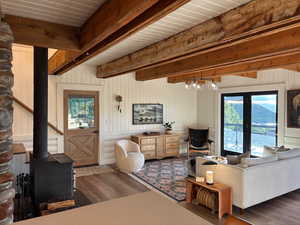 Living area with a wood stove, dark wood finished floors, and wood walls