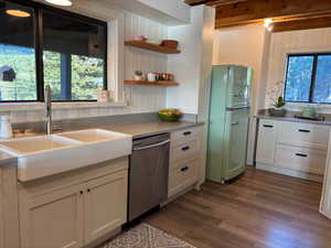 Kitchen featuring freestanding refrigerator, dishwasher, dark wood-style flooring, white cabinets, and open shelves