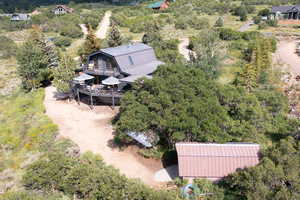 Aerial view of property and surrounding area with a tree filled landscape