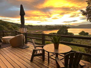 Deck at dusk featuring a water and mountain view