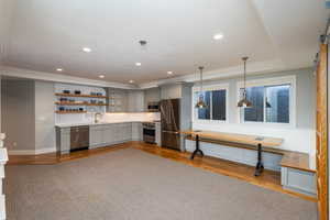 Bar featuring gray cabinetry, open shelves, stainless steel appliances, crown molding, and tasteful backsplash