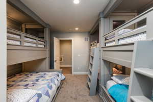 Bedroom featuring light colored carpet, recessed lighting, and a textured ceiling