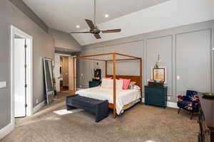 Bedroom featuring lofted ceiling, carpet floors, a decorative wall, and ceiling fan