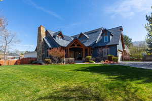 View of front of house with covered porch, a chimney, solar panels, concrete driveway, and a garage