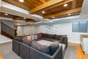 Living area with light wood-type flooring, recessed lighting, and a wooden ceiling with exposed beams