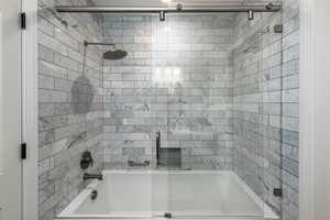 Bathroom featuring bath / shower combo with glass door